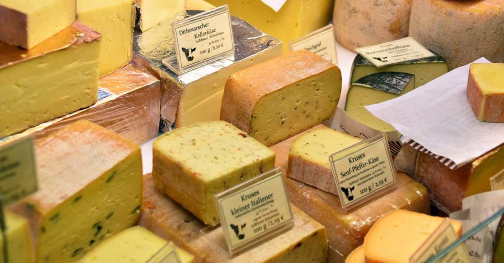 Einige verschiedene Käsesorten in einer Käsetheke. Viele Menschen leiden an Käse Unverträglichkeit.