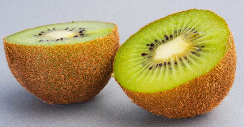 Nahaufnahme einer aufgeschnittenen Kiwi. Kiwis können die Ursache für eine Kiwi-Allergie sein.