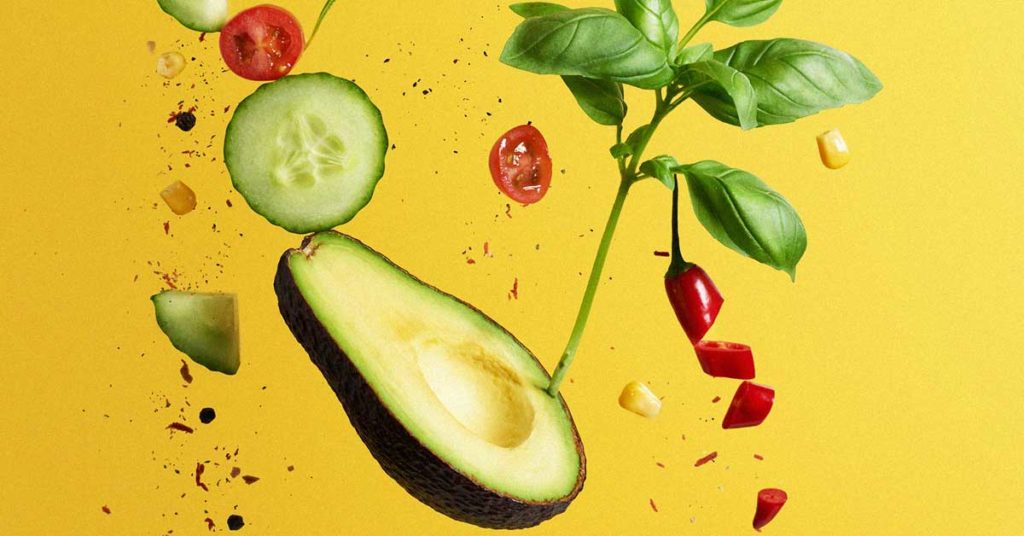 Abbildung einiger nährstoffreicher Lebensmittel: Avocado, Basilikum, Tomaten, Chili, Mais und Gurke. Eine unausgewogene Ernährung kann einen Nährstoffmangel bewirken.