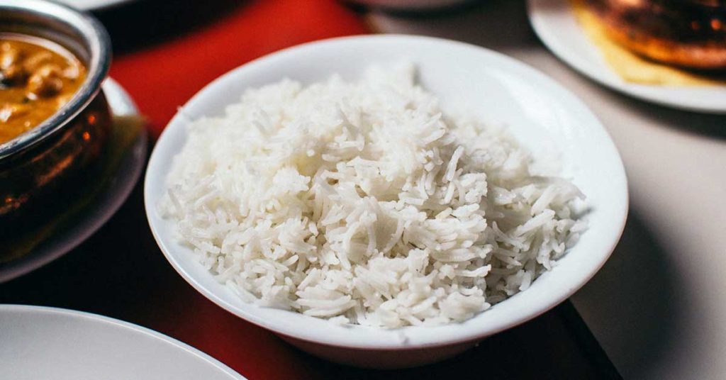 Ein weißer Teller voll weißem Reis. Dieser ist oft die Ursache für eine Reisunverträglichkeit.